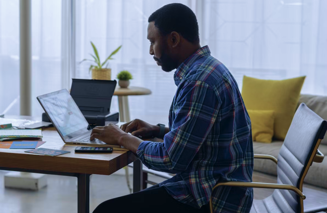 a man works on a computer on a desk