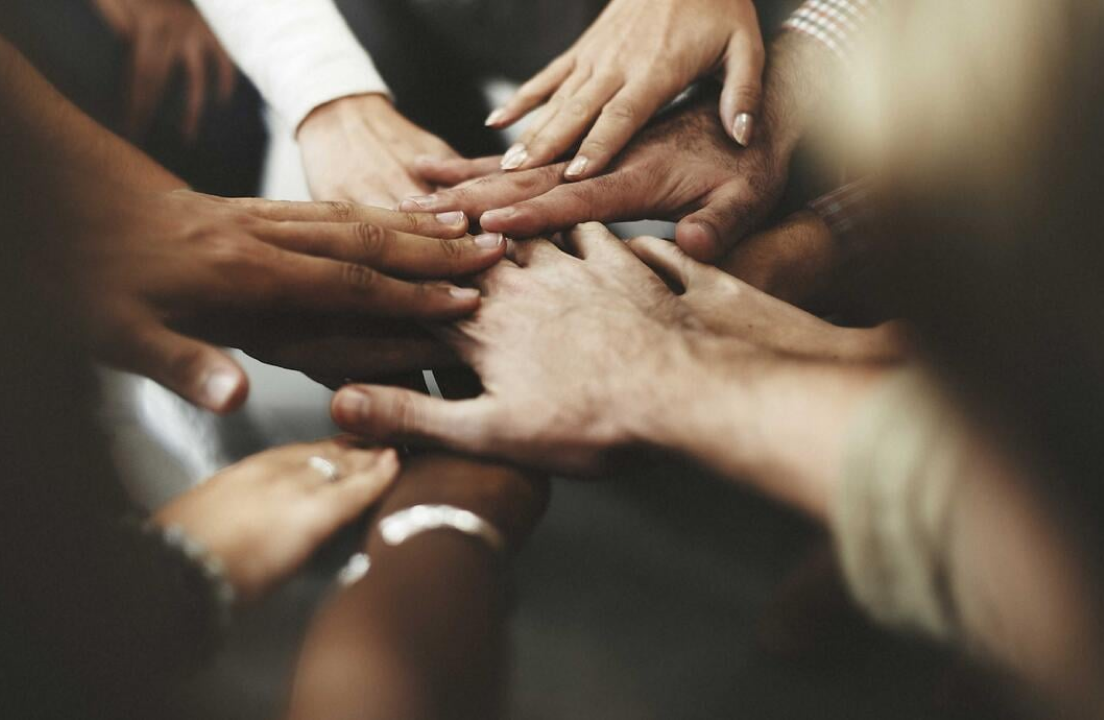 several hands together in a circle