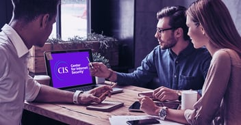 Two men and a woman discuss the Center for Internet Security while looking at a laptop screen