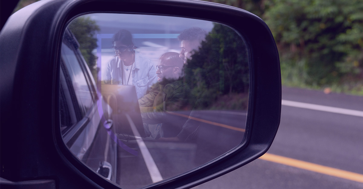 3 cybersecurity experts reflected in a car side view mirror suggesting a look backward